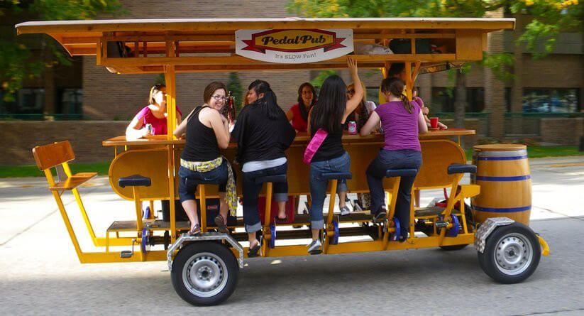 Group of people on pedal bike with drinks