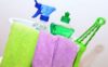 Basket with cleaning supplies and towels hanging over the basket