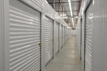 Well-lit, indoor hallway of white storage units