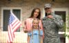 military family holding the key to a new house after they've moved