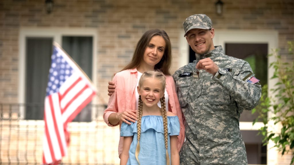 military family holding the key to a new house after they've moved