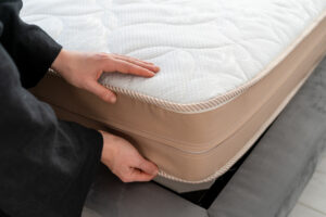 Hand on orthopedic memory foam mattress.