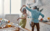 senior couple in aprons dancing and smiling