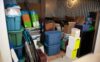 A storage unit is packed full of bins, boxes, and other items.