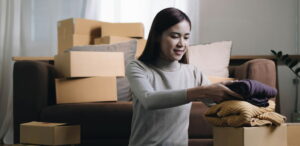 A student packs up sweaters and other boxes as she moves out of her dorm.