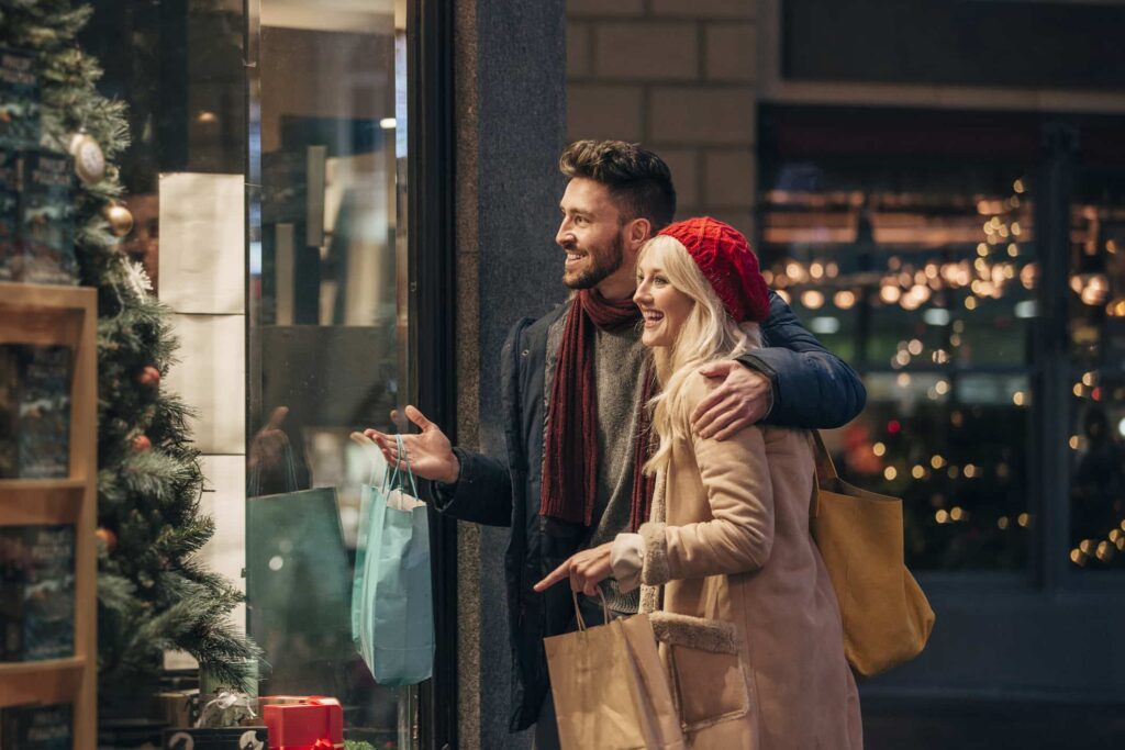 A couple browses a festive winter display while shopping for the holidays