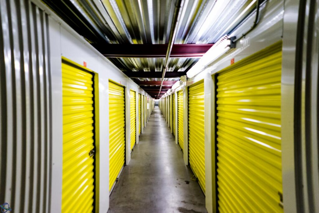 A hallway of indoor self storage units that stretches far and long.