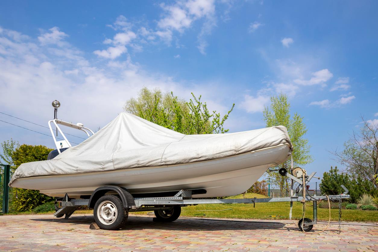 A boat parked outside at a vehicle storage facility.
