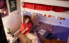 A college student sits in her dorm studying after moving in.