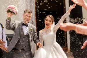 A happy couple leaves a church after their wedding.