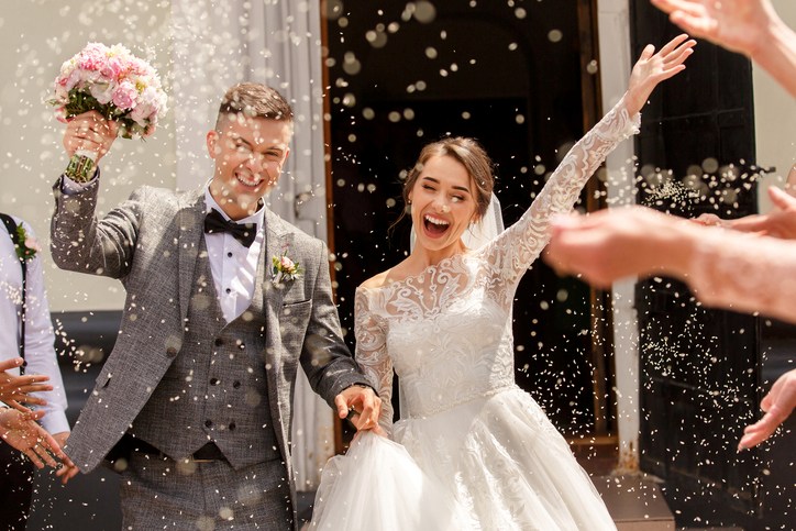 A happy couple leaves a church after their wedding.