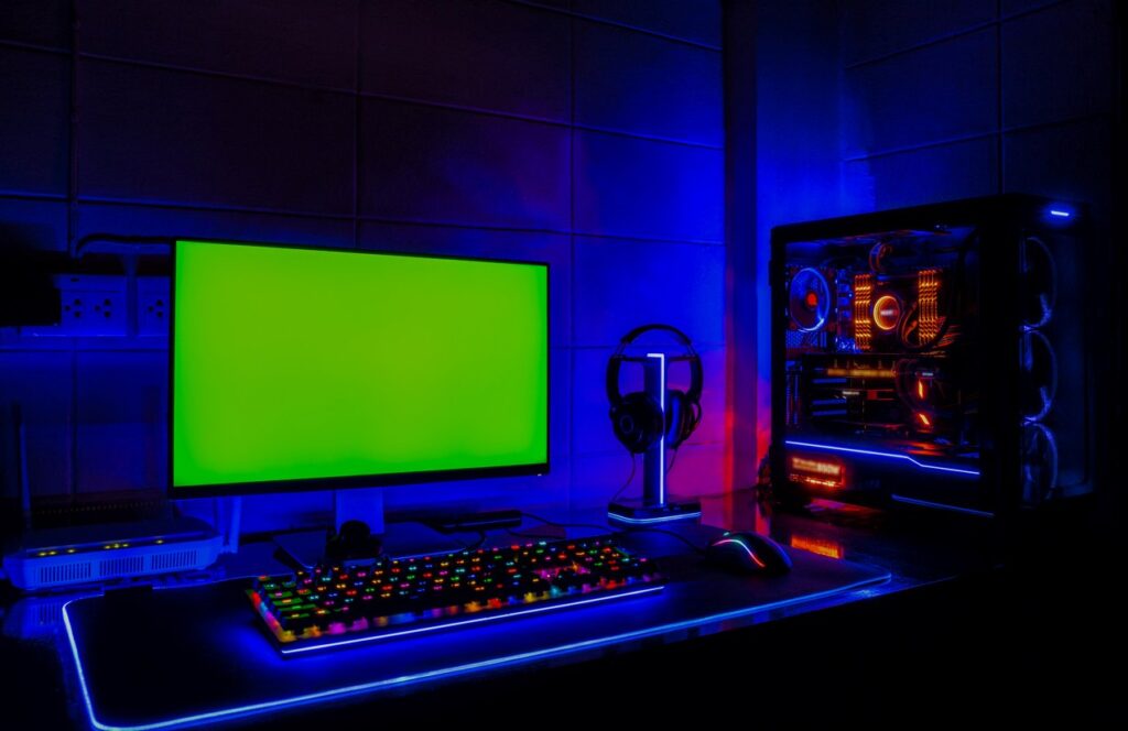 A gaming room with a PC, a widescreen monitor, and LED lighting.