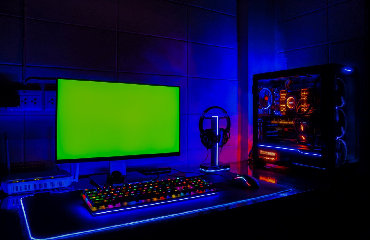 A gaming room with a PC, a widescreen monitor, and LED lighting.