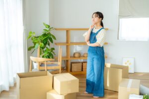 A young woman packing boxes in her living room.