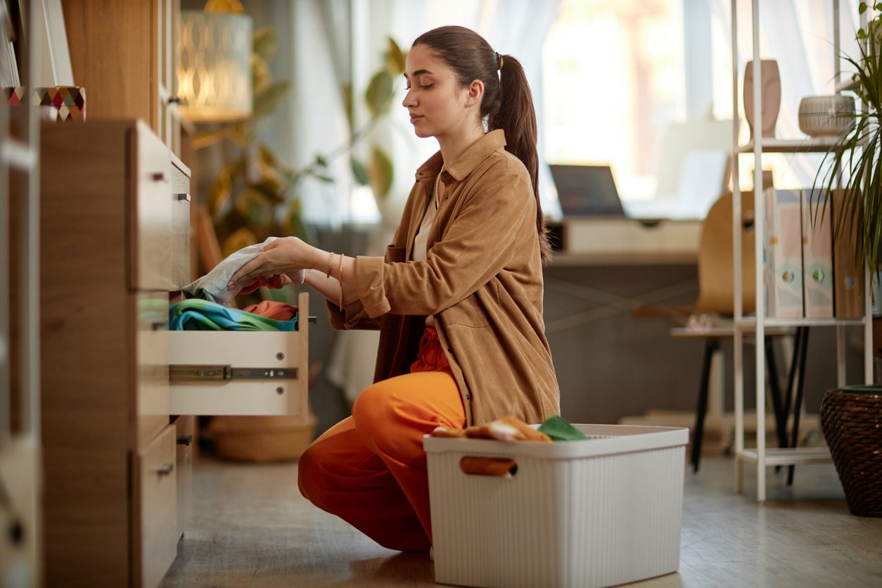 Young woman organizing freshly cleaned clothes.