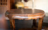 A vintage style oak tree material round table, furniture object for antique room decoration. Close up and selective focus on table edge's part.