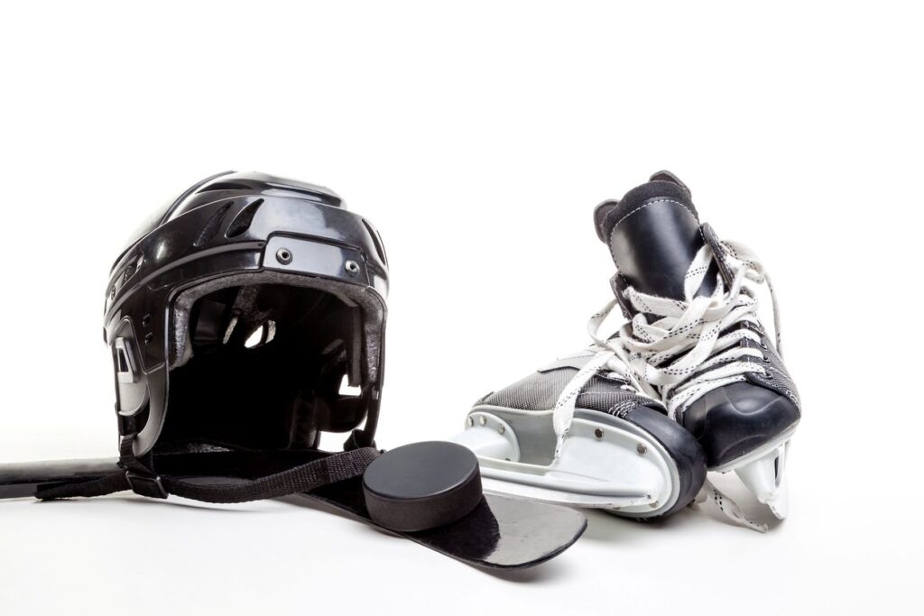 Assorted pieces of hockey equipment sitting an a floor.