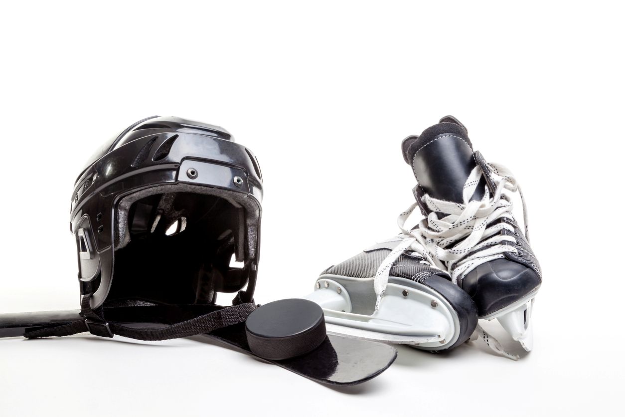 Assorted pieces of hockey equipment sitting an a floor.